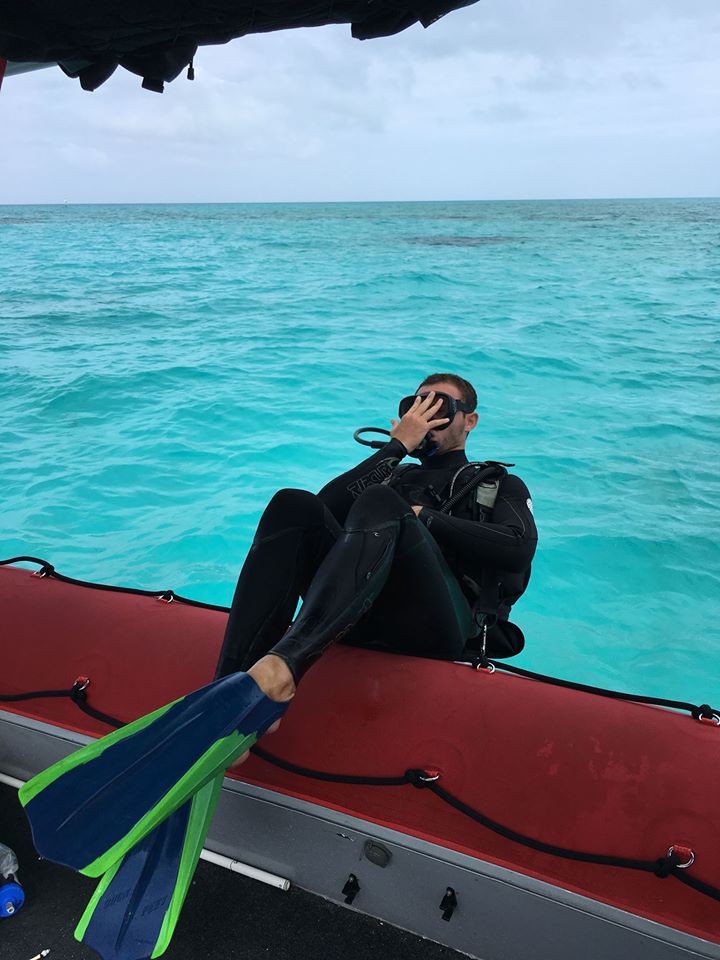 A diver goes over side of boat